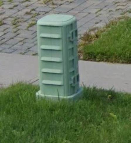 A light green Rogers pedestal box on a boulevard.
